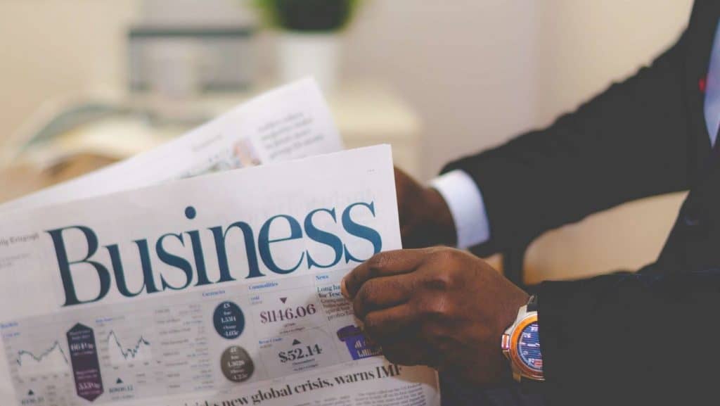 person holding business section of newspaper