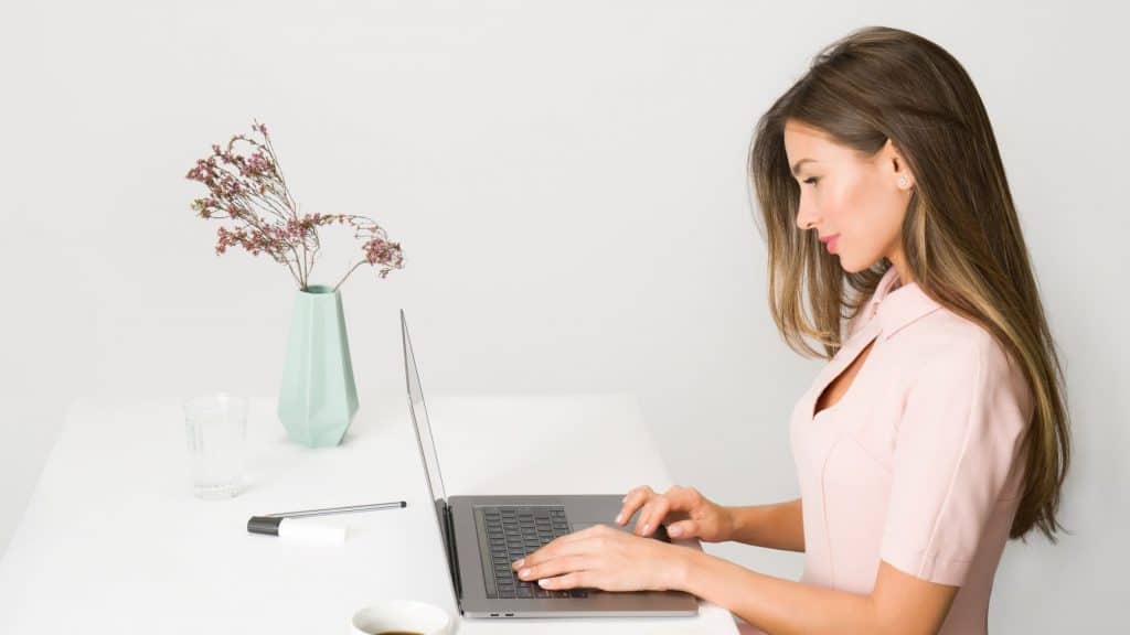 woman in pink dress using laptop