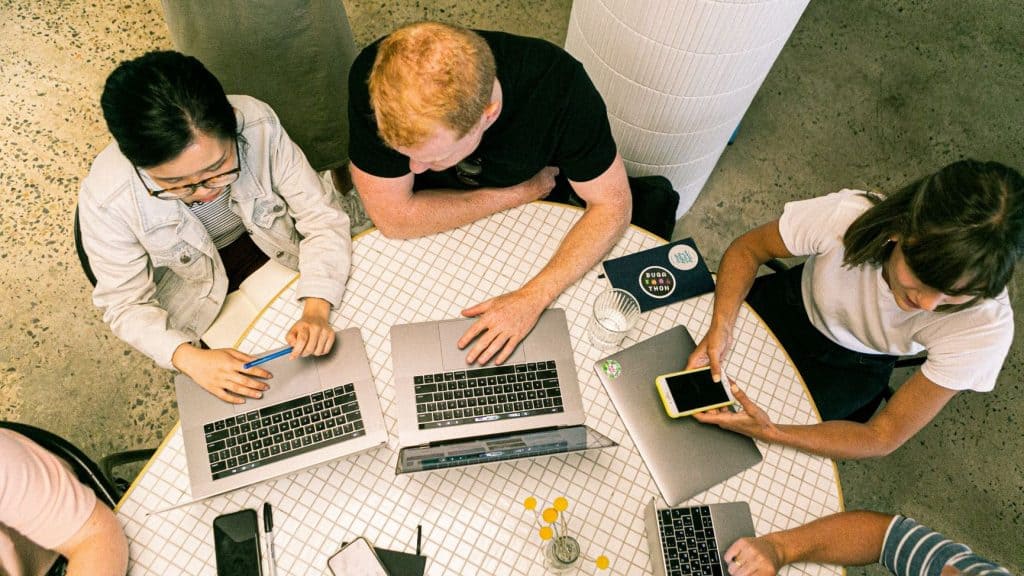 three people at a startup working on branding together on their laptops