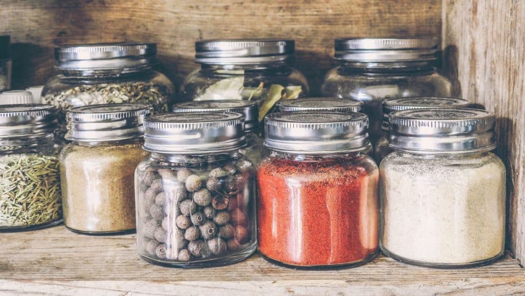 glass jars with spices on a shelf with no branding or packaging design