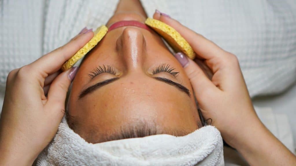 woman in white towel getting facial