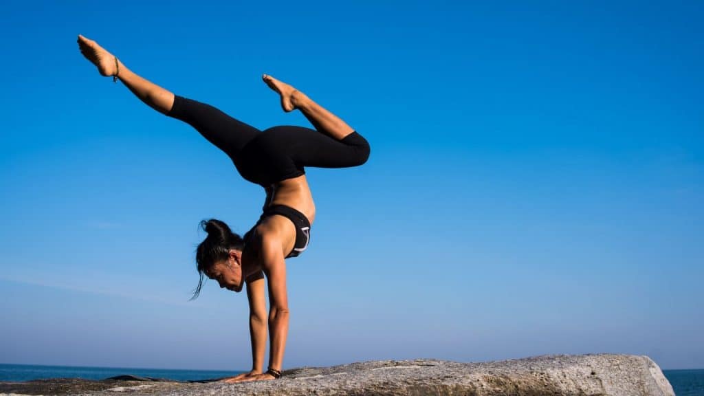 woman doing yoga on a rock 