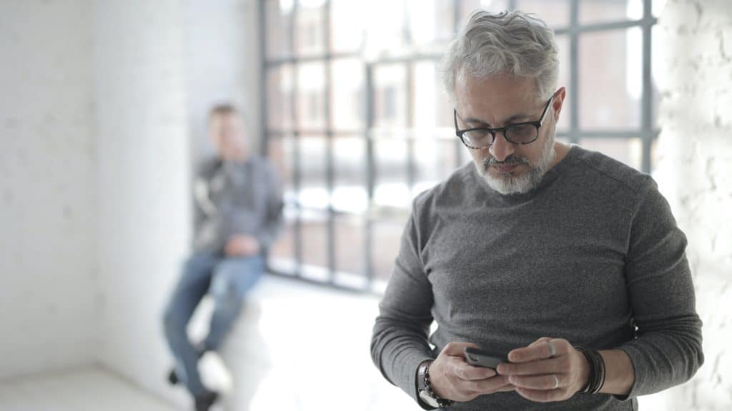 man on phone with a friend in the background