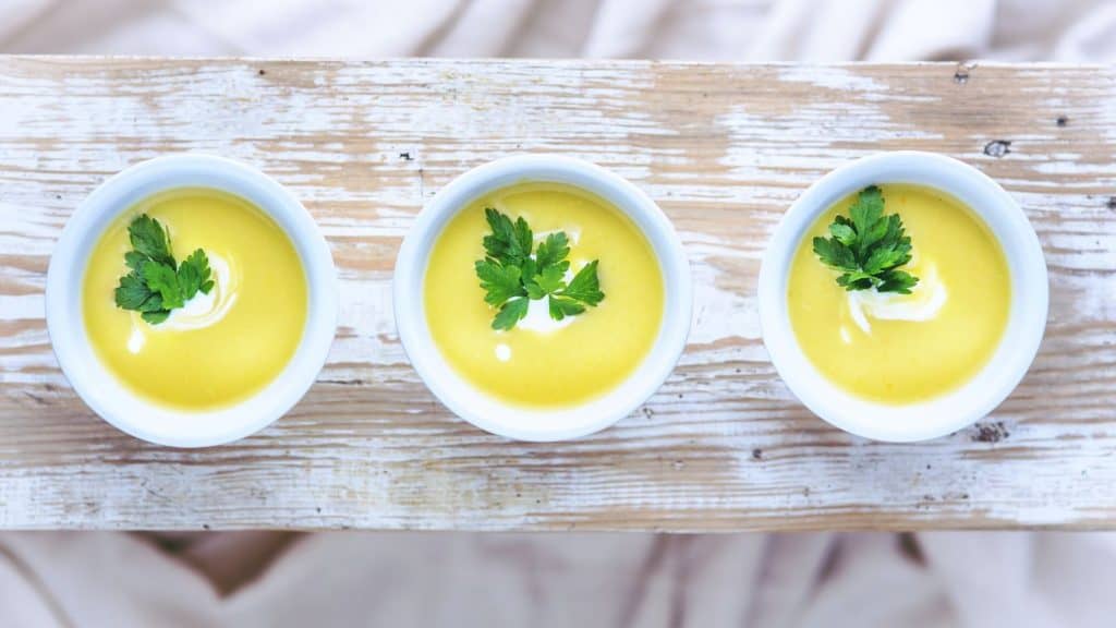 three bowls of yellow soup