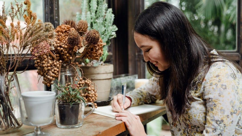 woman writing business plan next to plants