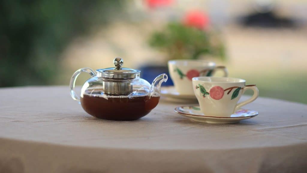 clear tea pot with tea cups