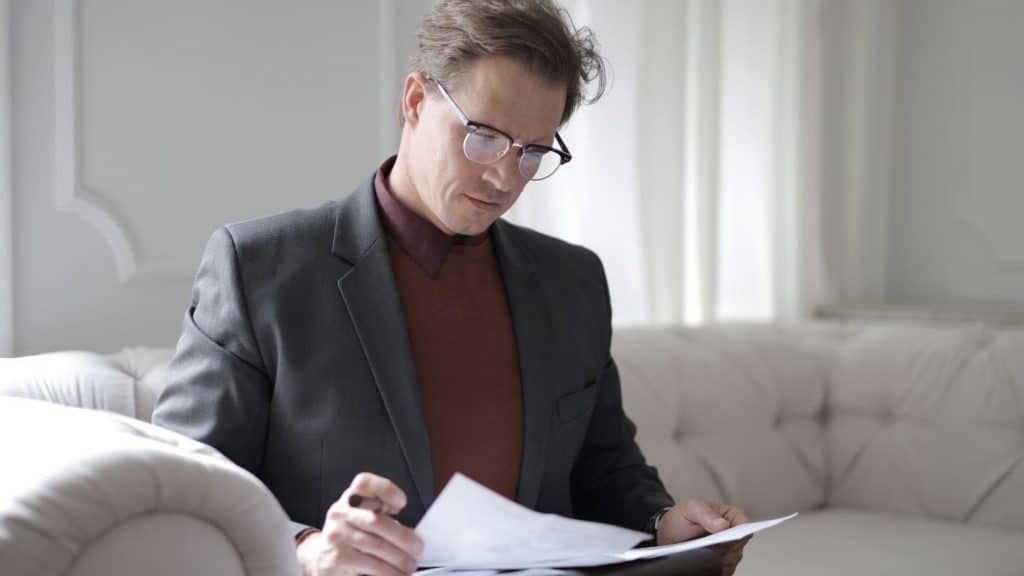 businessman looking at papers on a couch