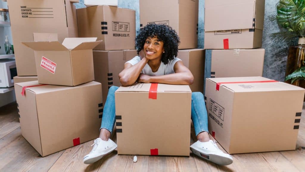 woman sitting in a room full of boxes