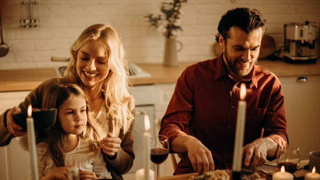 family eating dinner with candles on the table