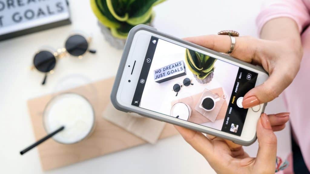 woman taking a photo of wellness products on her phone