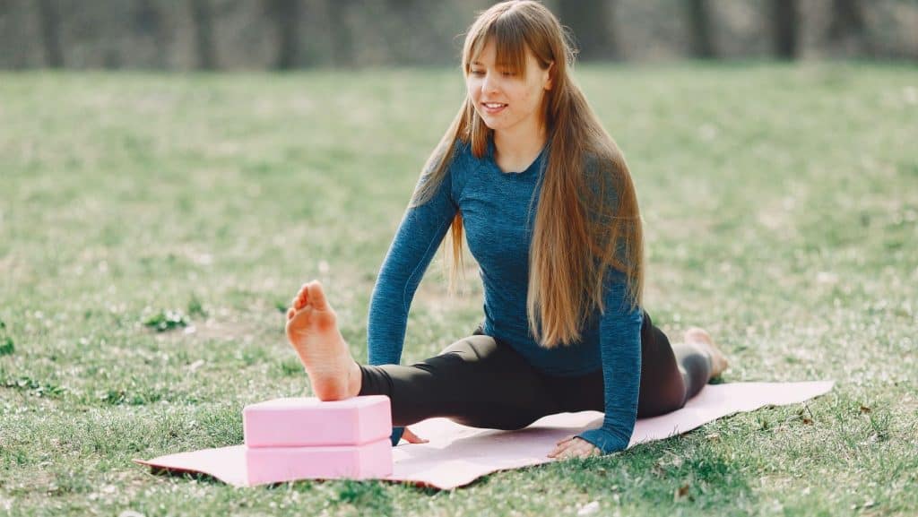 teenager exercising with a yoga mat and yoga blocks