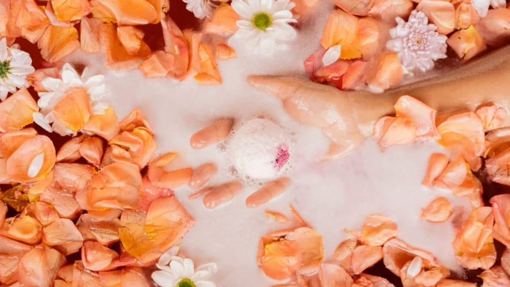woman holding a bath bomb with flowers