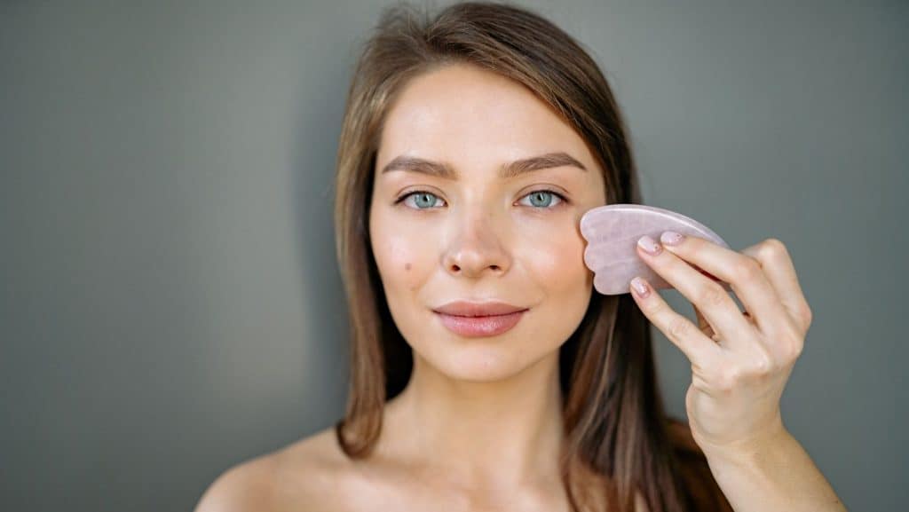 woman using skin care product on face