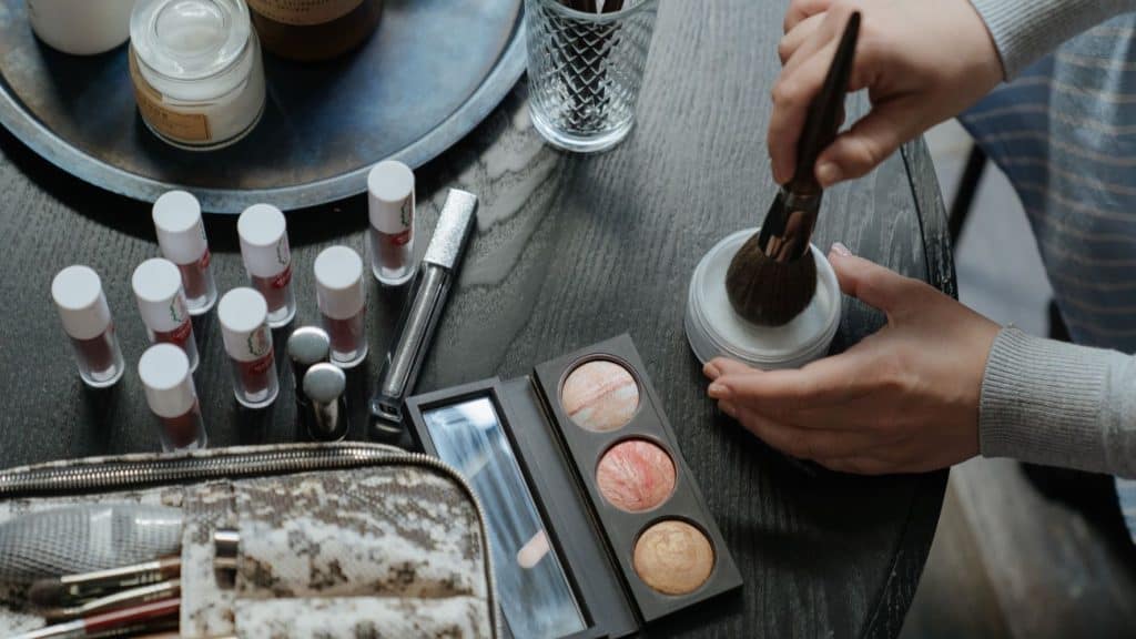 woman holding beauty products on black table