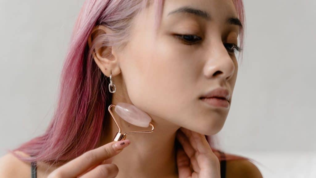 self care marketing of woman using face roller