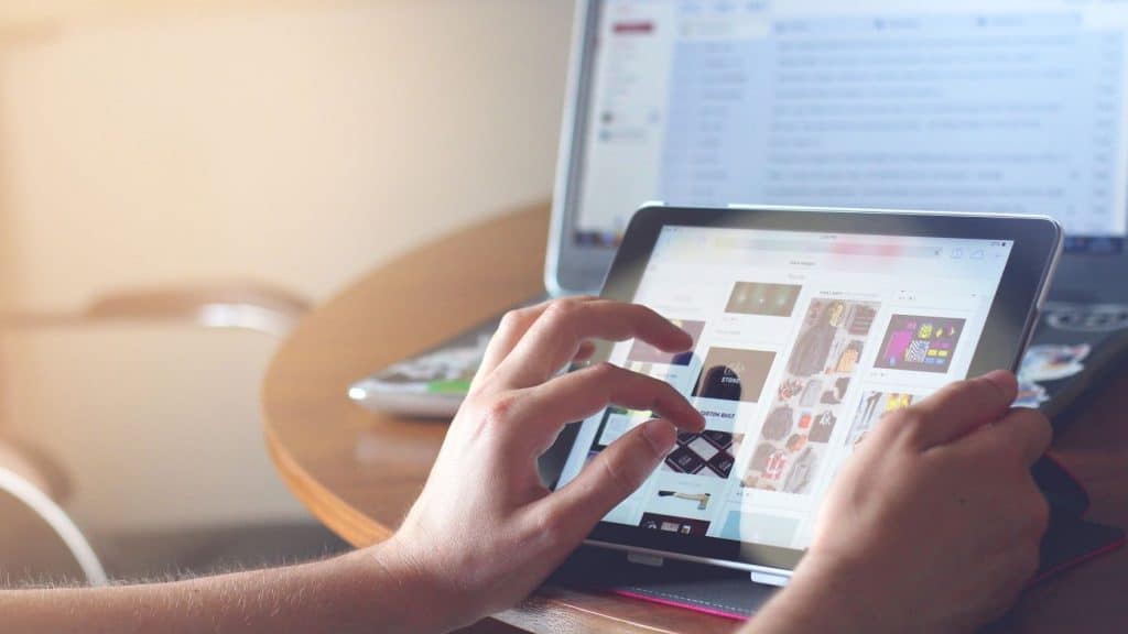 hand on tablet scrolling through pinterest