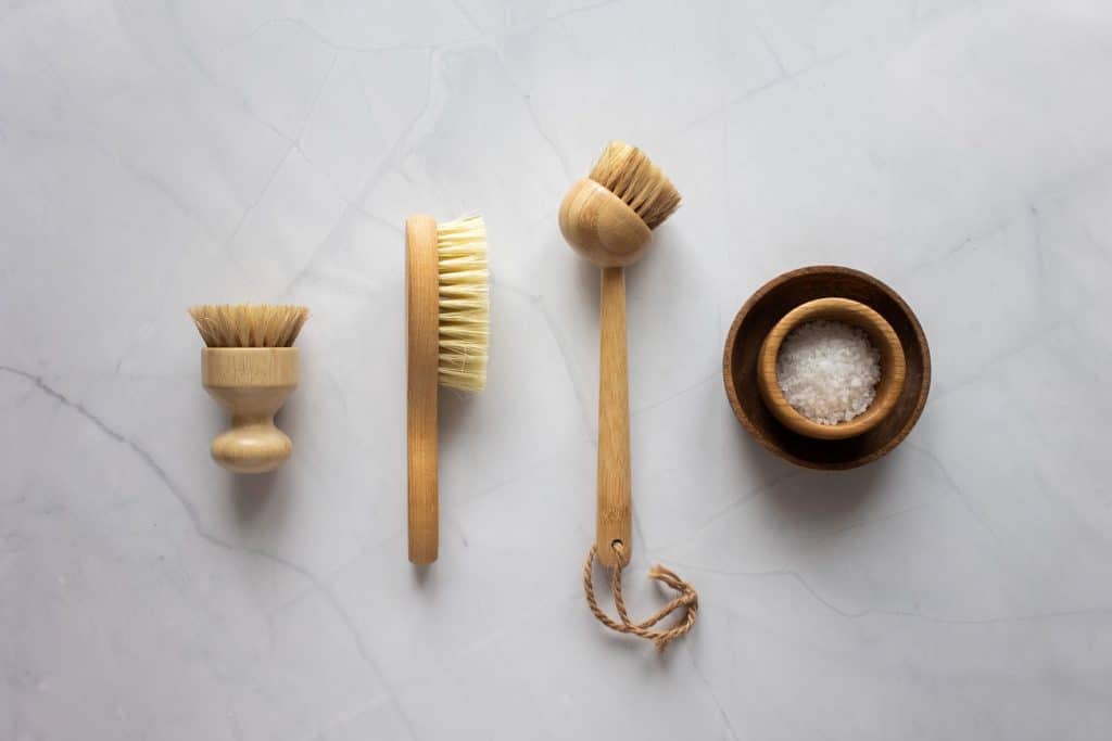skin care brushes and body salt on a white counter