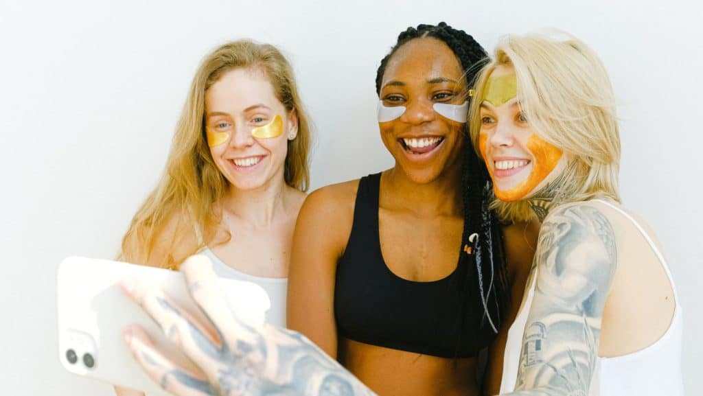 three diverse women wearing skincare products