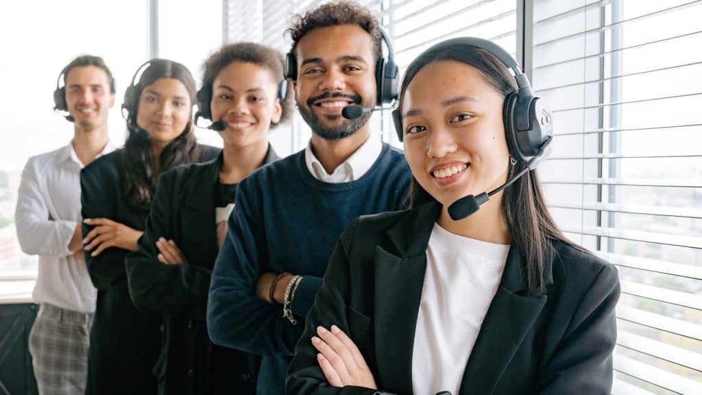 five person customer support team wearing headsets