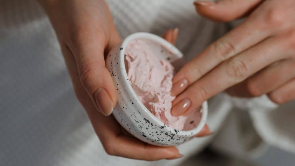 woman using skincare lotion
